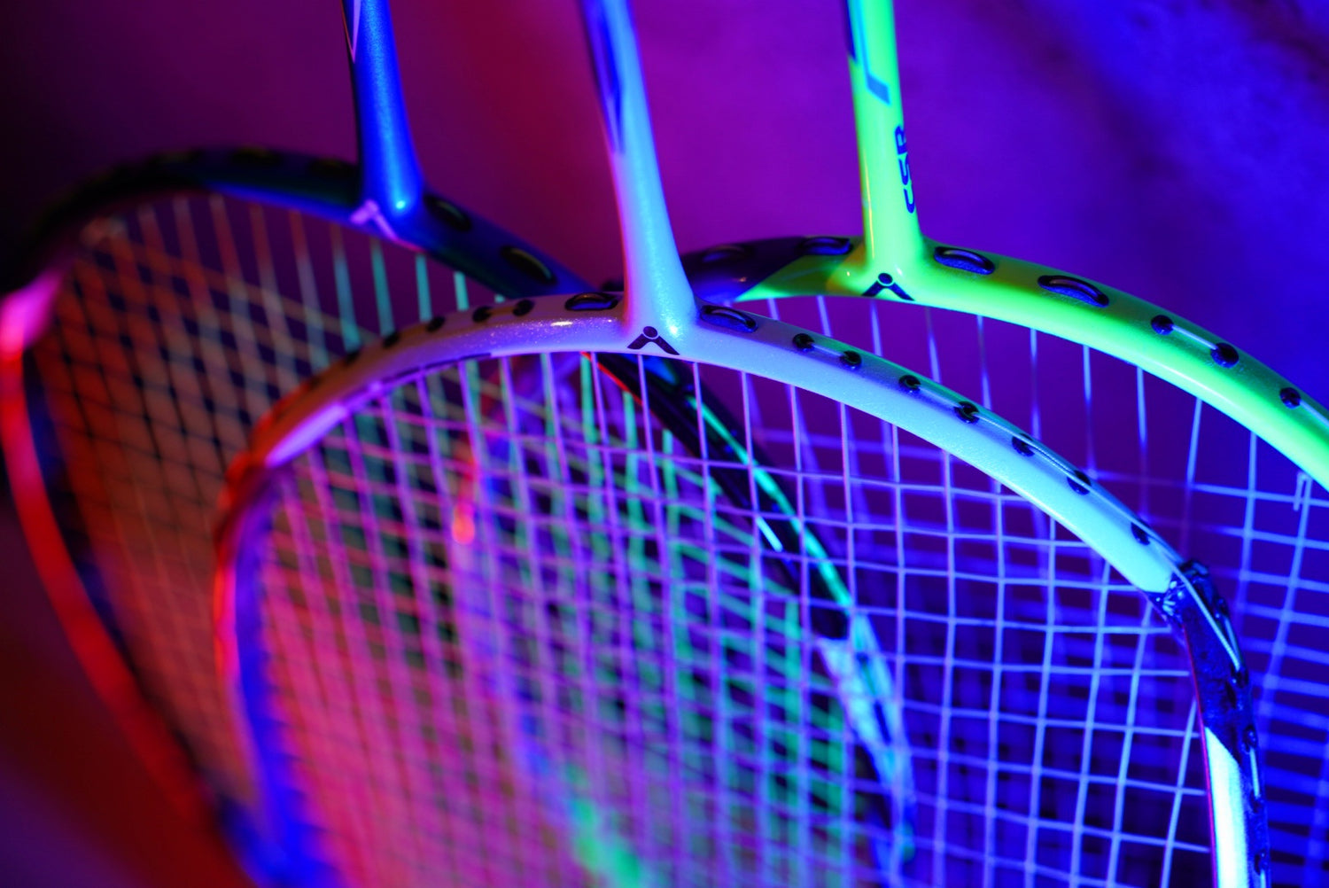 Drei Badmintonschläger in blau rotem Neonlicht